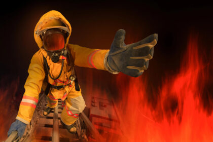 Pompier în luptă cu flăcările pentru stingerea unui incendiu. Pompier salvator de vieți.