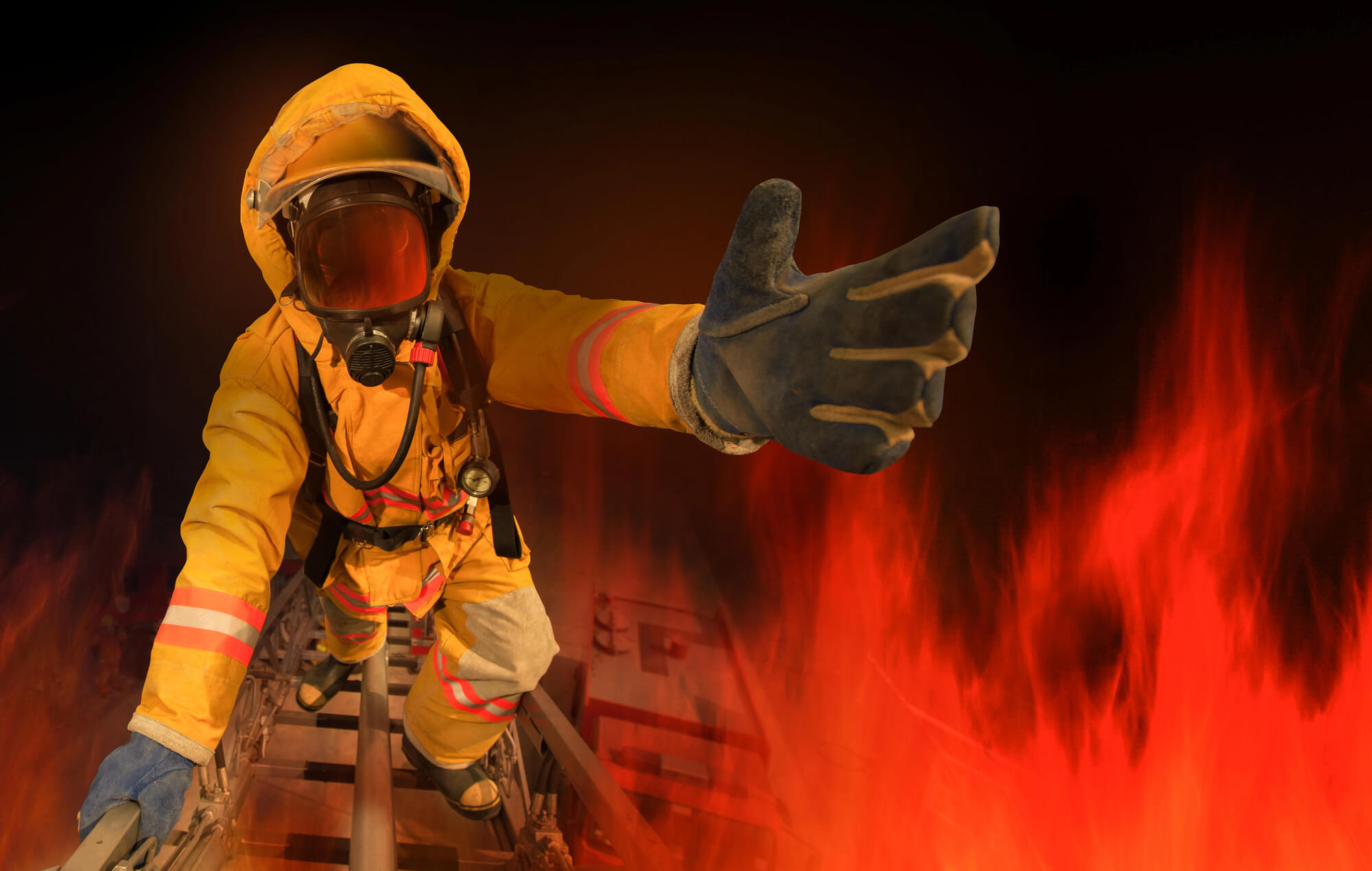 Pompier în luptă cu flăcările pentru stingerea unui incendiu. Pompier salvator de vieți.