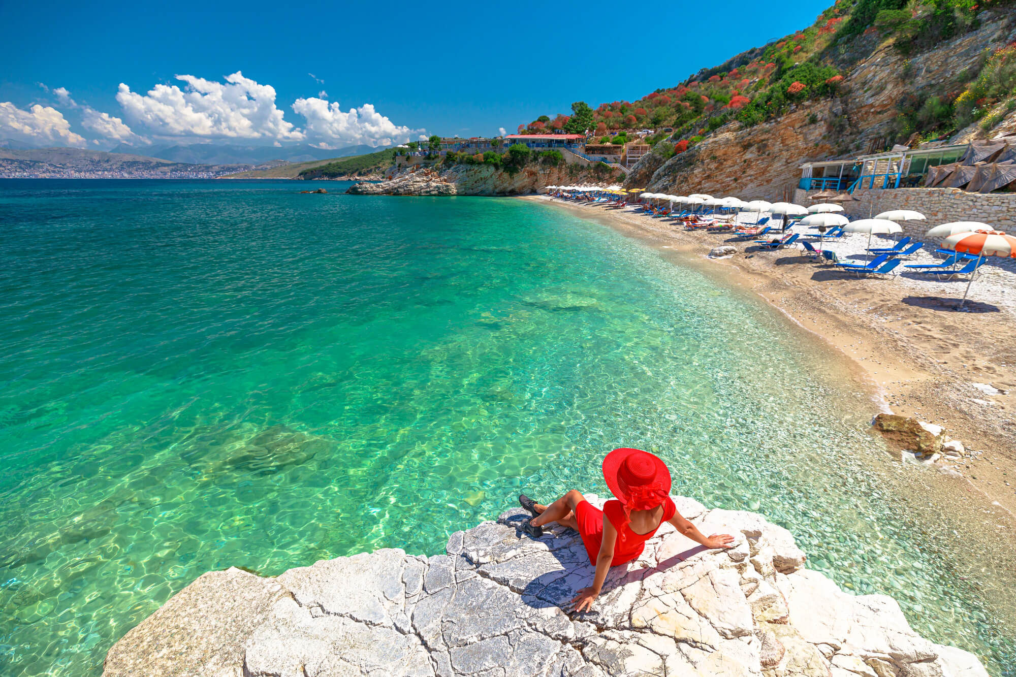 Femeie stând la soare pe Pulebardha Beach în Albania.