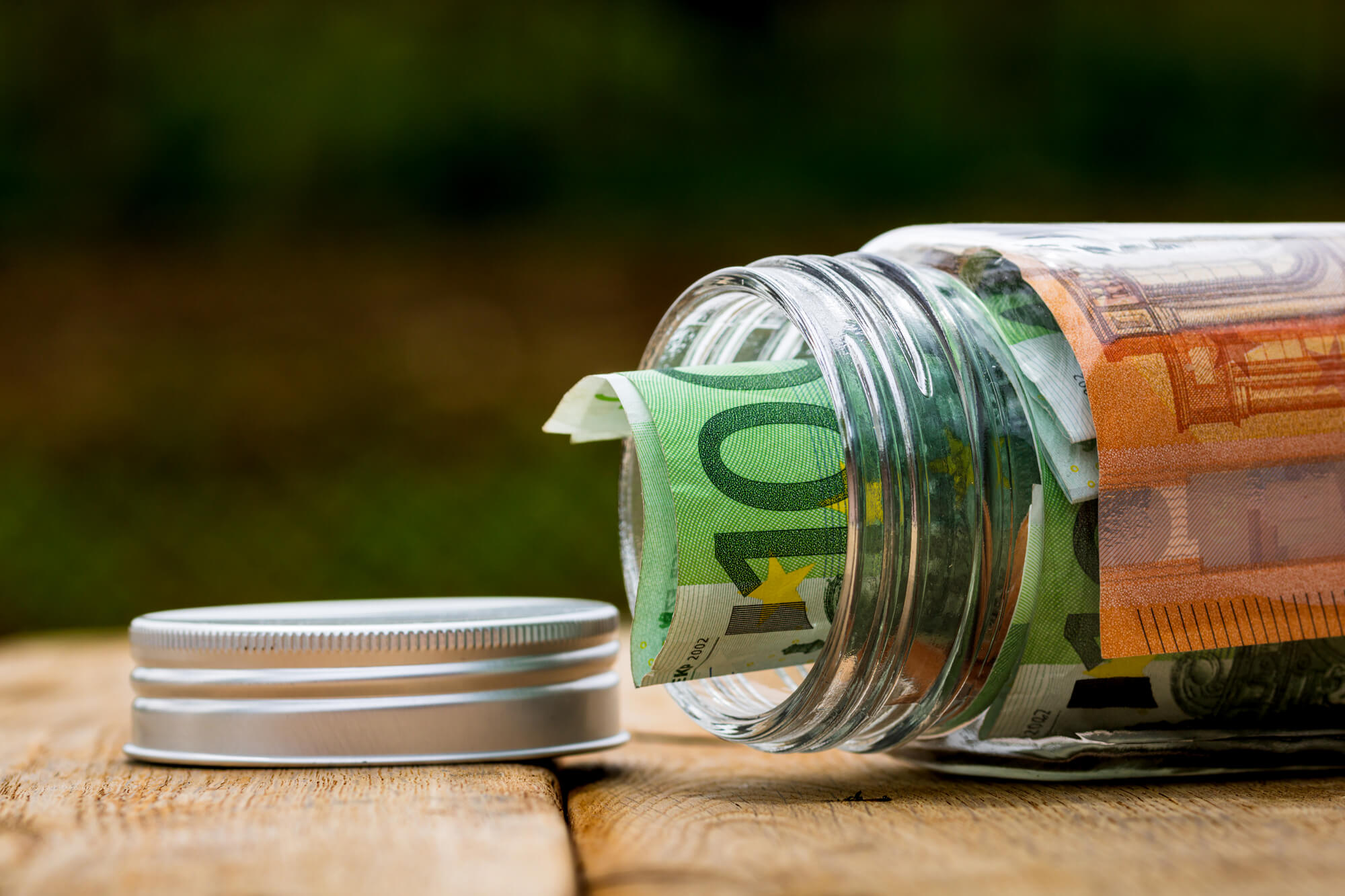 Borcan cu bancnote euro pe o masă de lemn, simbol pentru curs euro în ianuarie-februarie 2026